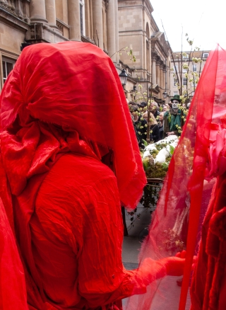 Extinction Rebellion's 'Red Rebels' viewing 'Mother Earth' on her funeral bier, Bath '24.