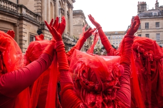 Extinction Rebellion's 'Red Rebels' before the funeral bier, Bath '24.